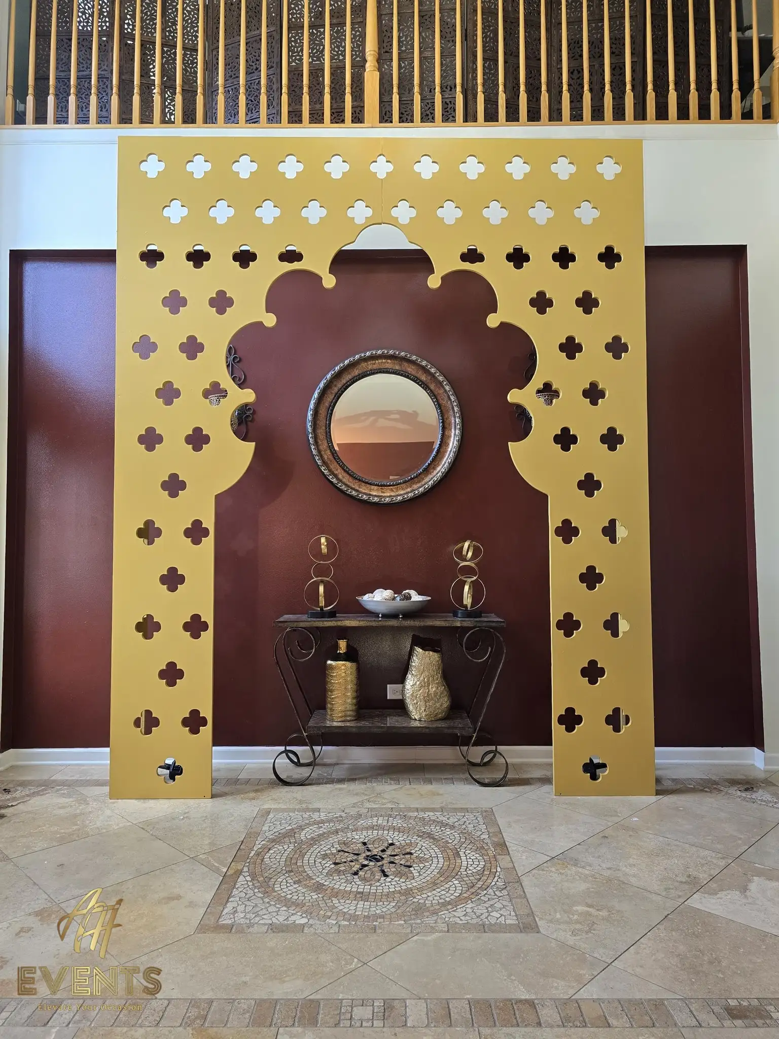 Satin gold portal arch with quatrefoil cut-outs and a scalloped opening in a two-story foyer
