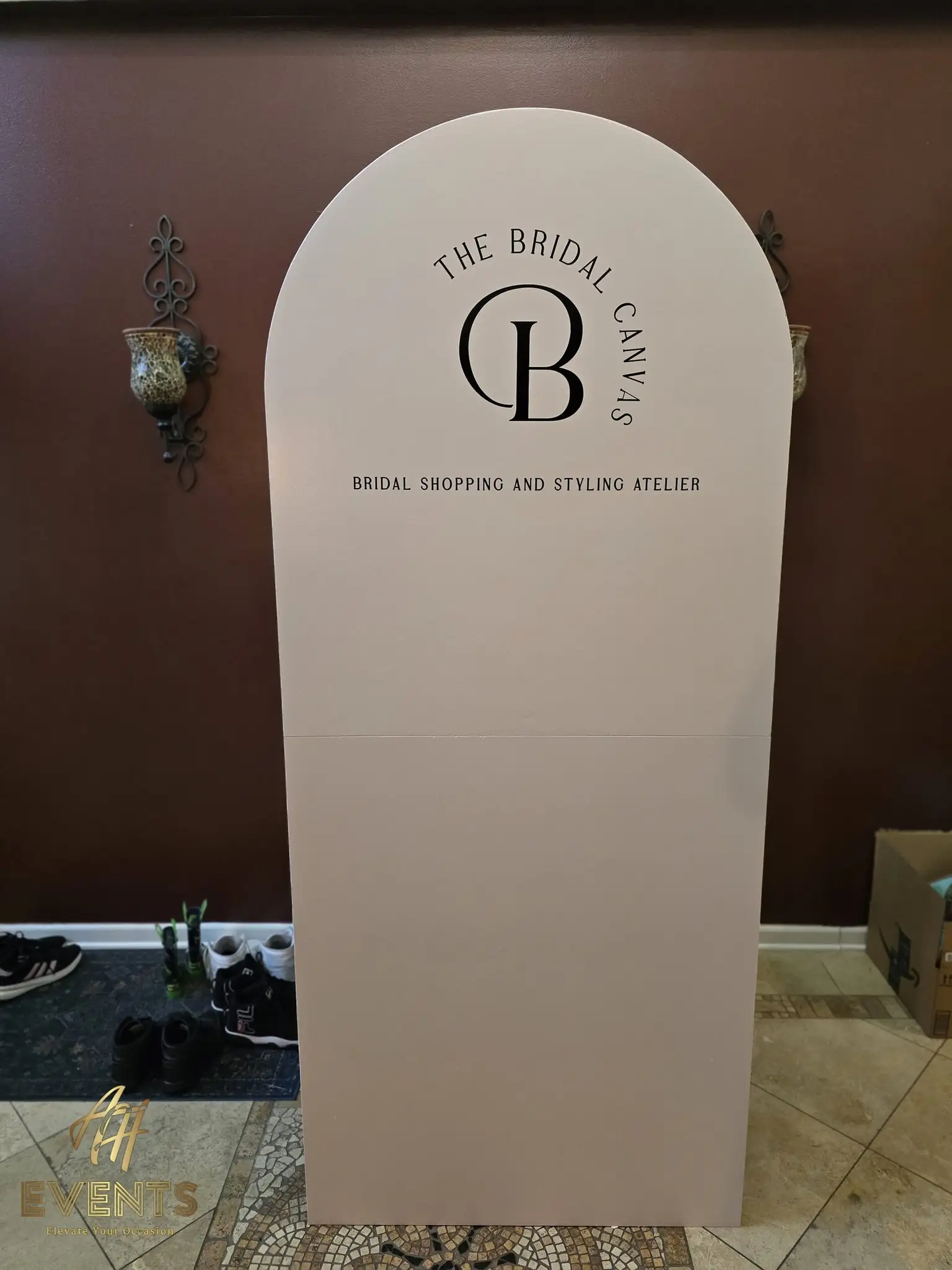 Cream arched sign panel reading 'The Bridal Canvas — Bridal Shopping and Styling Atelier' with a monogram, displayed in a home