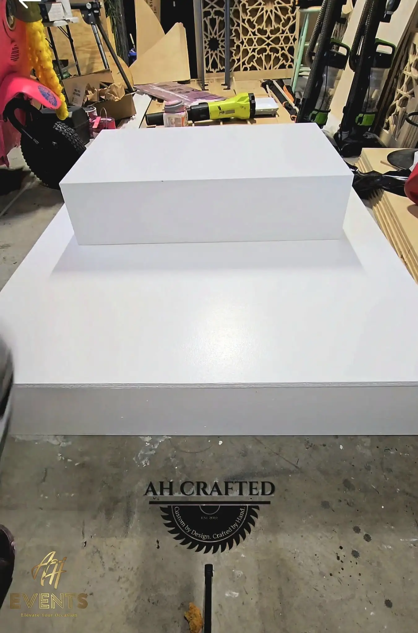White stepped riser box set on a larger white platform in the workshop, marked with the AH Crafted logo
