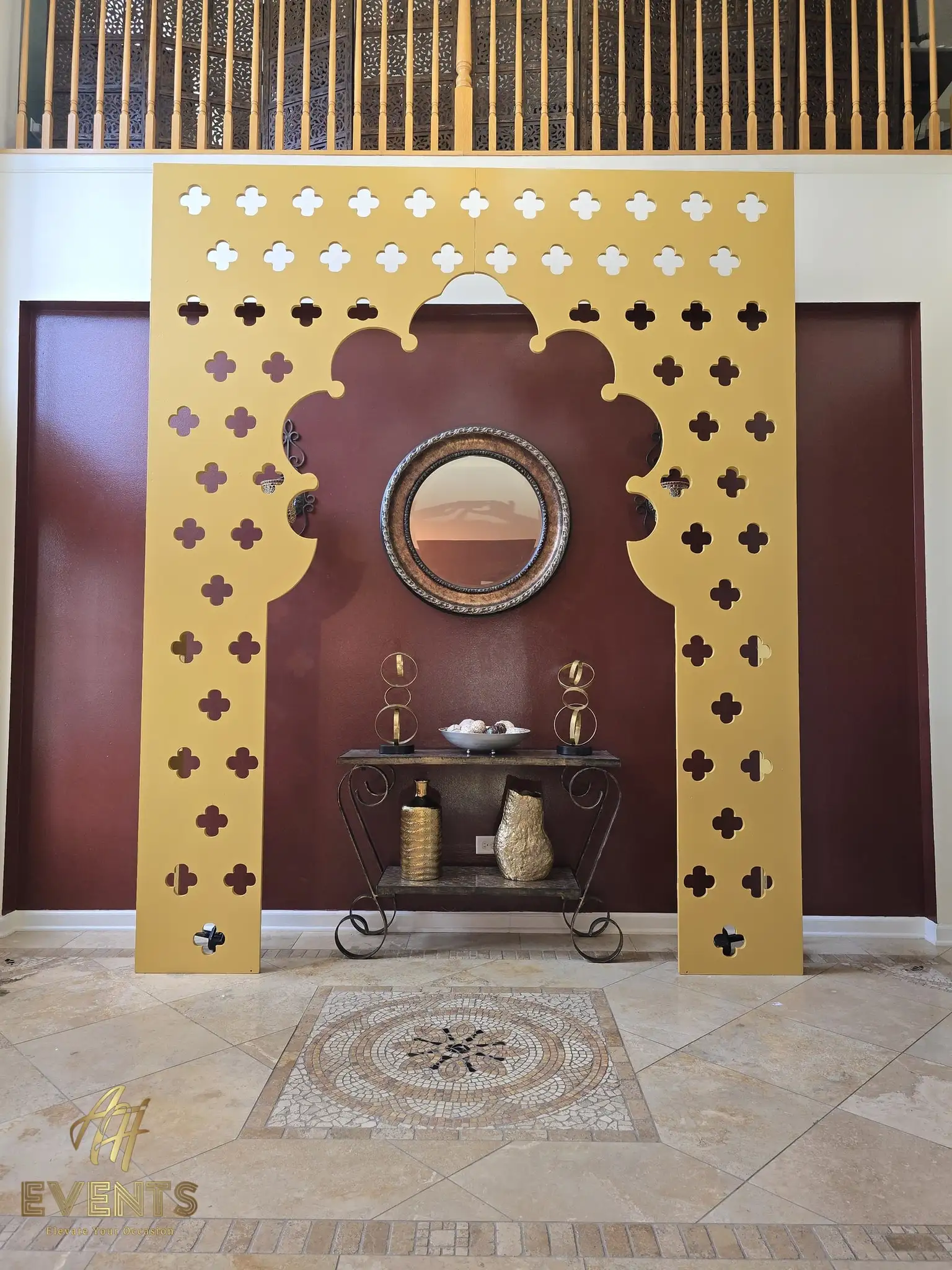 Satin gold quatrefoil-cut arch with a scalloped top in a foyer, front view