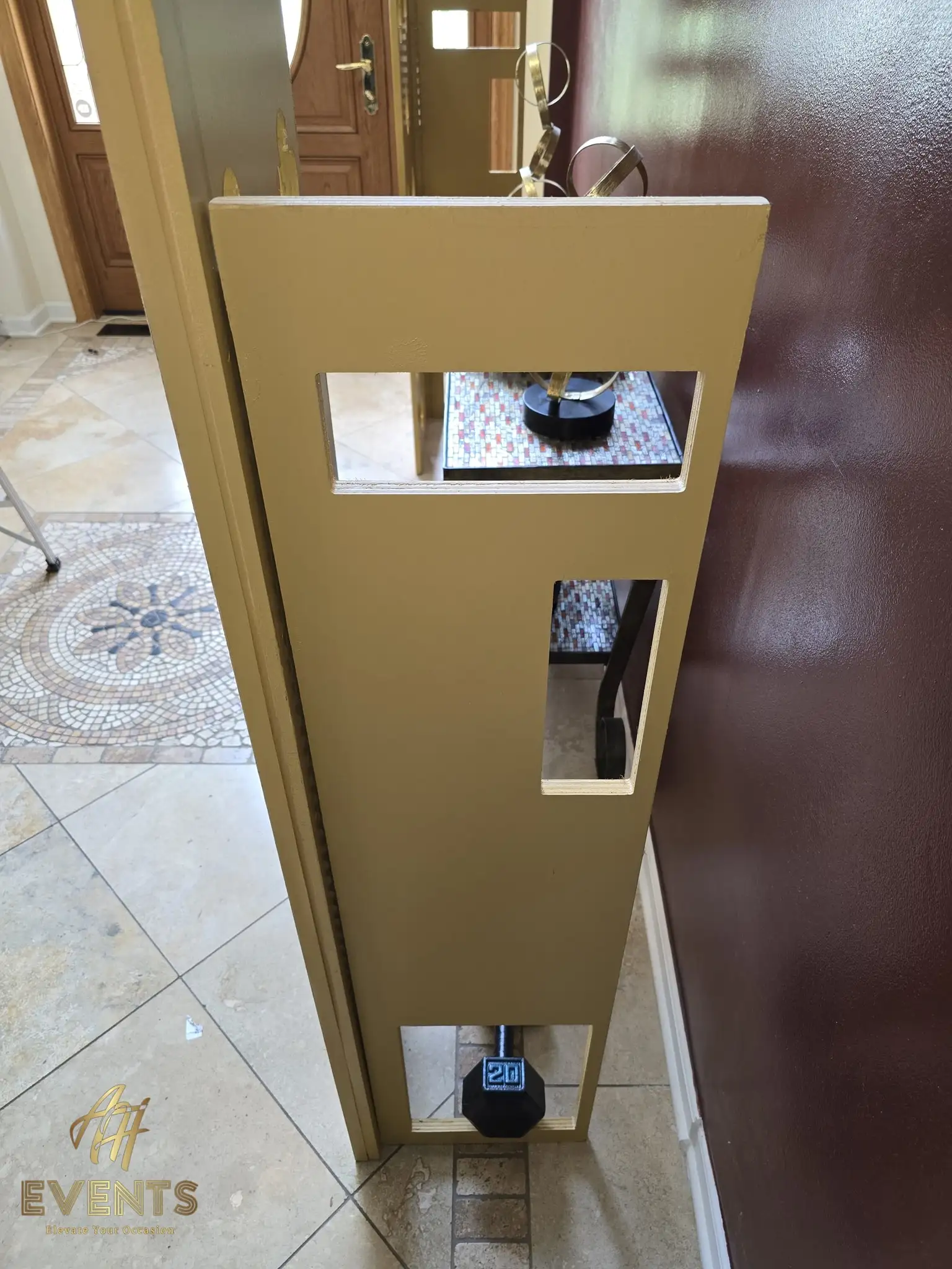 Satin gold arch with quatrefoil cut-out side panels and a scalloped opening in a two-story foyer