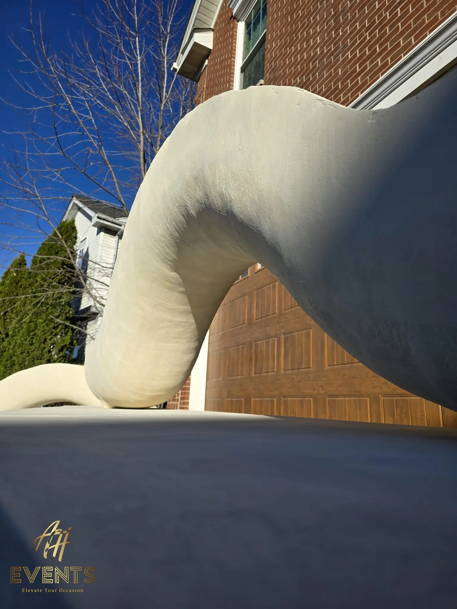 Low-angle view of a sculpted white serpentine arch form curving up from the stage platform