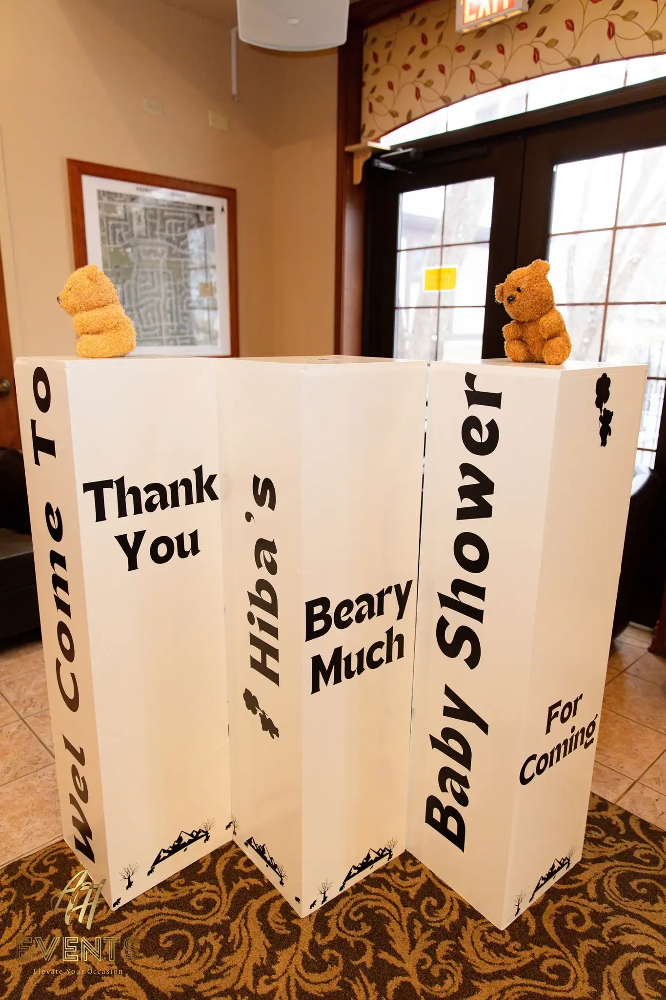 Angled view of the bear-themed baby shower welcome and thank-you letter boards with teddy bears on top