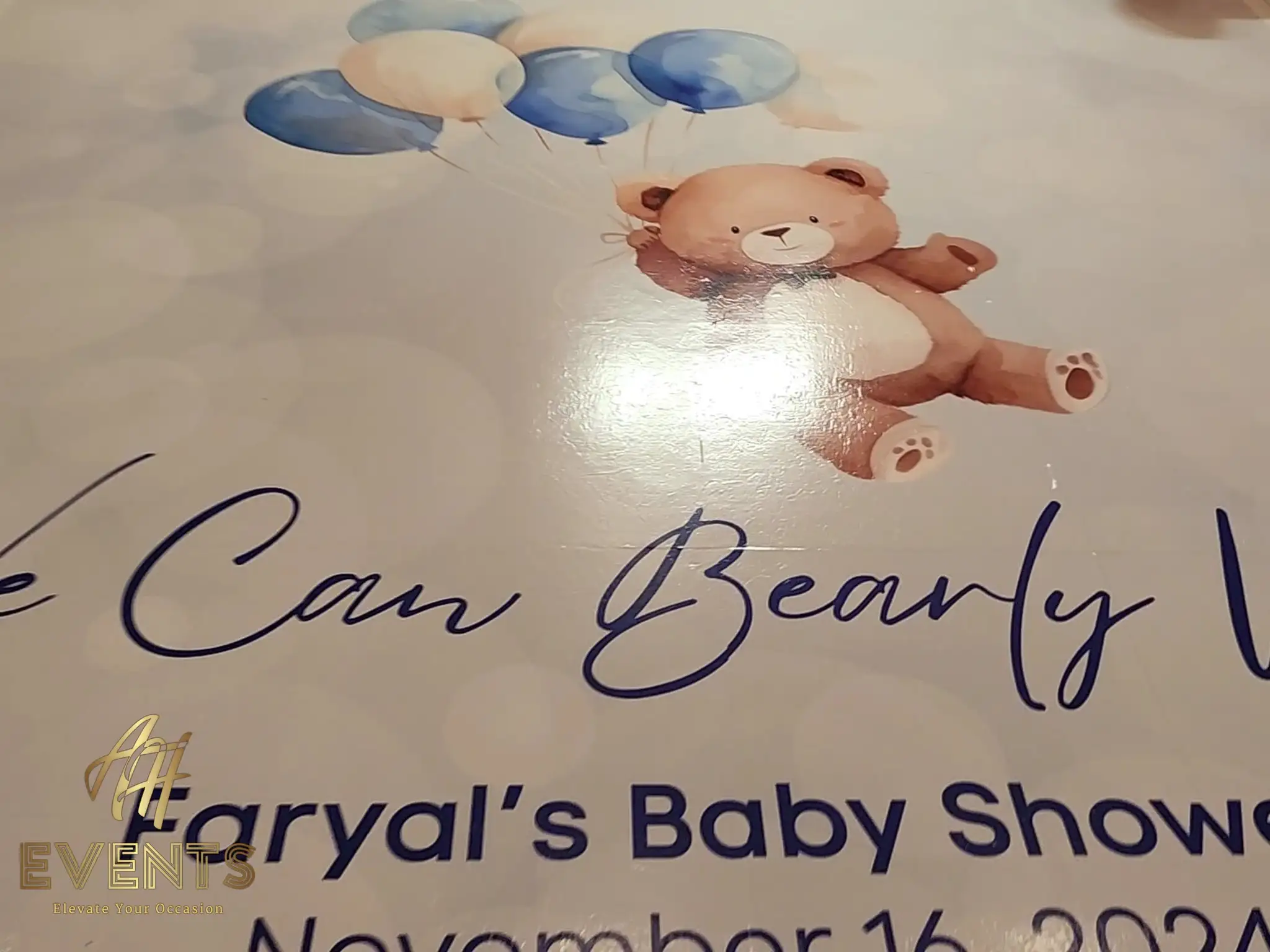 Close-up of the baby shower floor decal — a watercolor teddy bear holding blue and cream balloons above 'We Can Bearly Wait' script