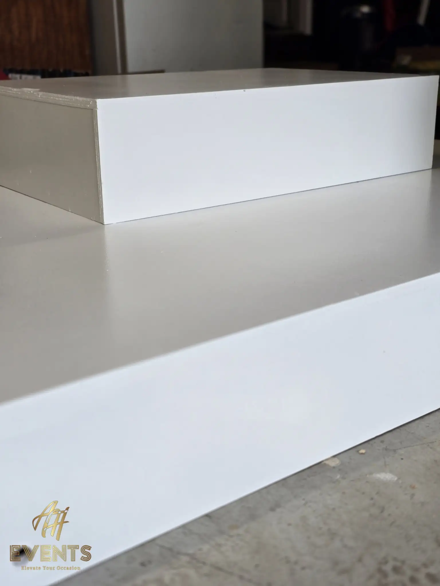 Two stacked white-painted platform boxes seen edge-on in the workshop