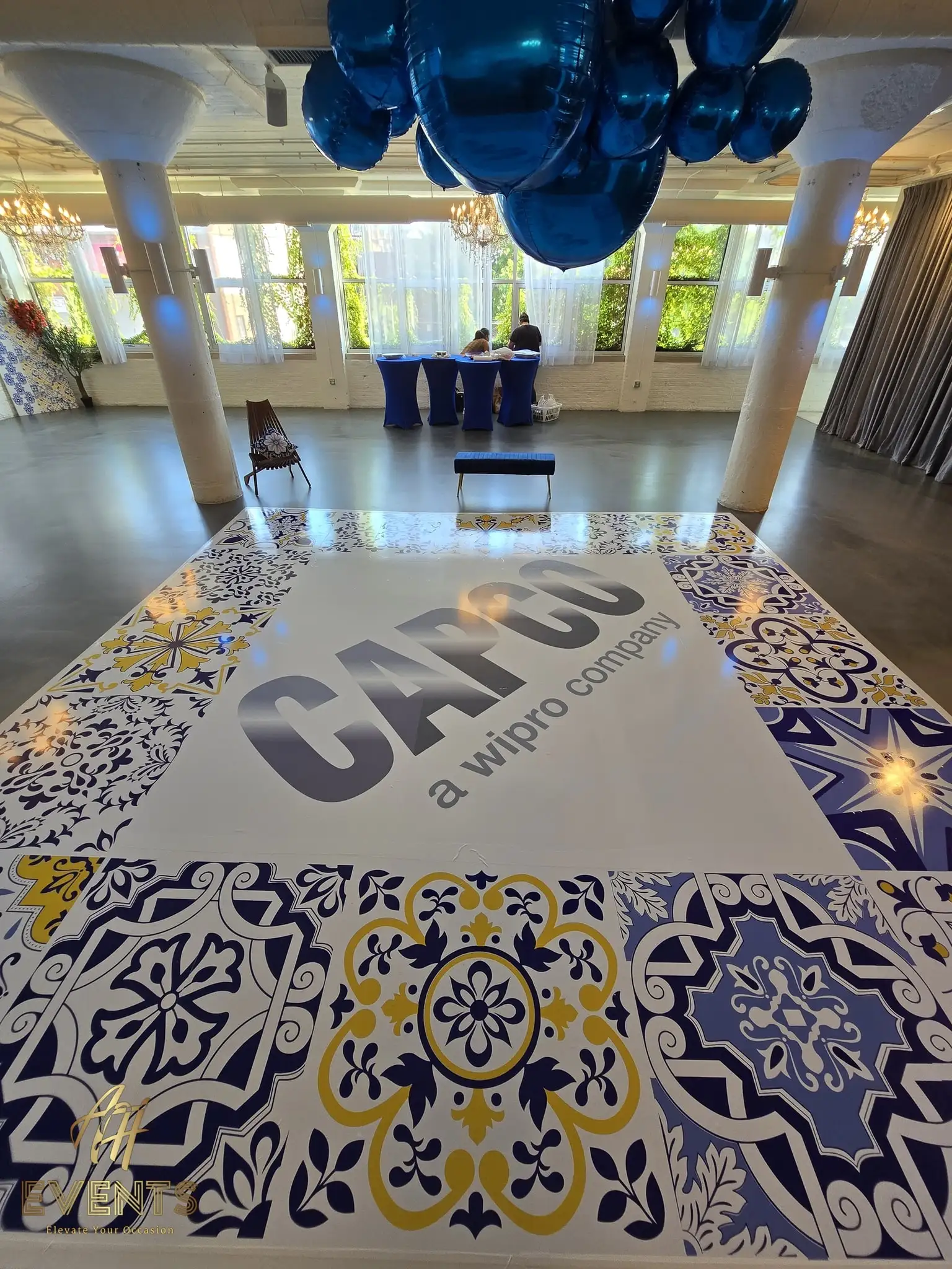 CAPCO-branded tiled dance floor in a loft venue with blue balloons and a registration table