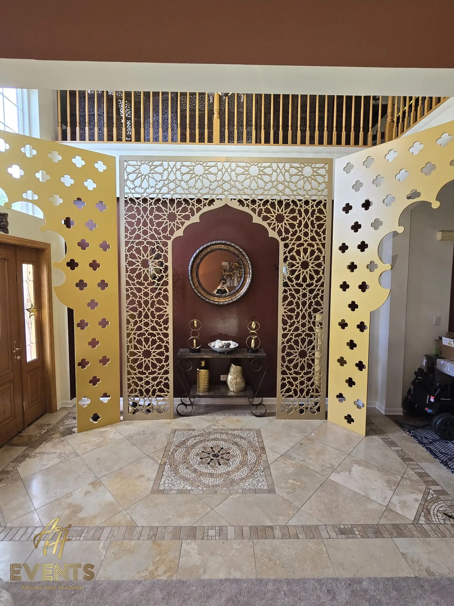Gold-painted arch panel with rectangular cut-out windows propped during a build, a dumbbell weighting its base