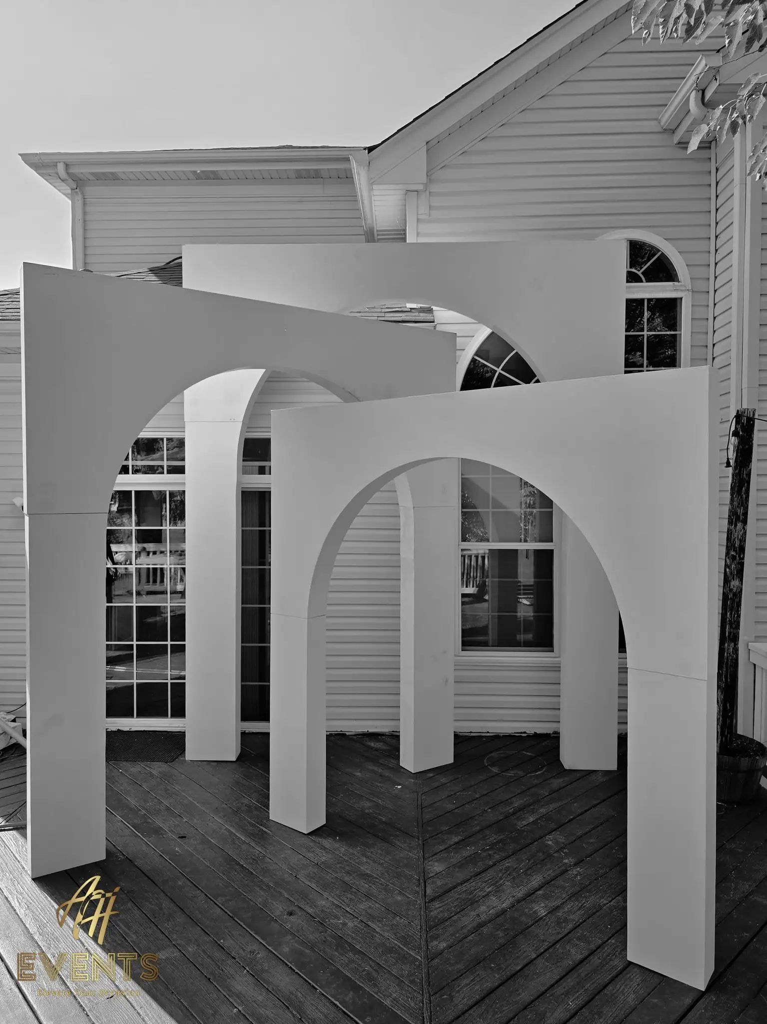Black-and-white view of the three nested white volumetric arches on a deck