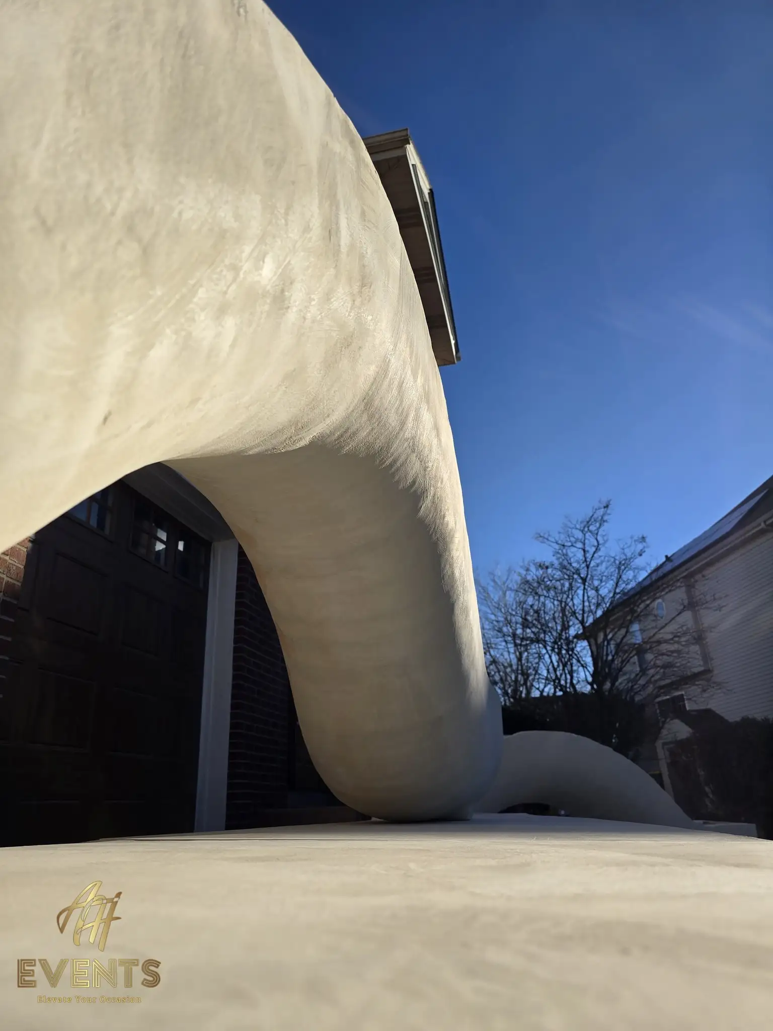 Sculpted white curved forms of the contoured stage seen from a low angle against a blue sky