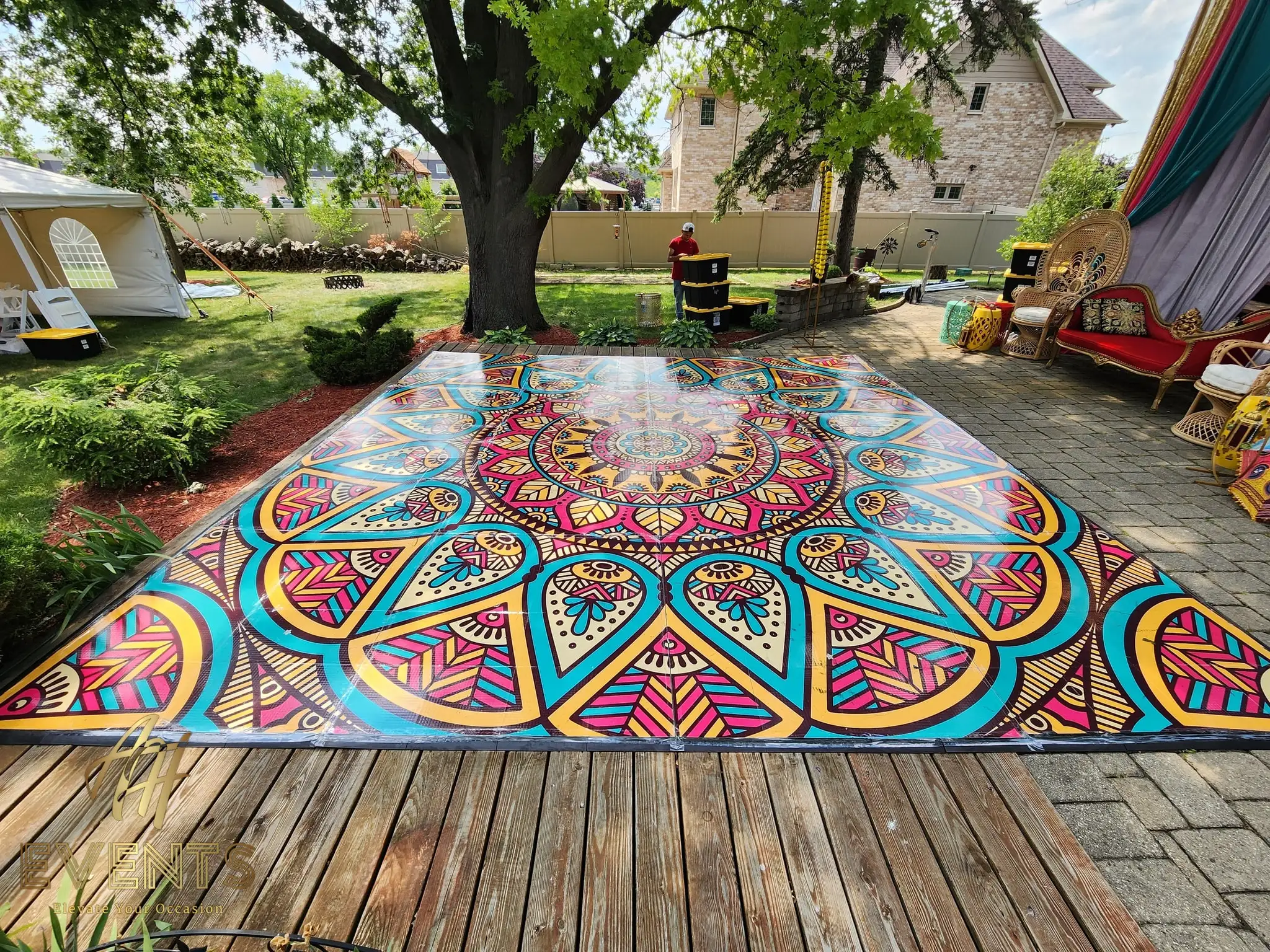 Mandala floor on a backyard wooden deck beside a lounge seating area