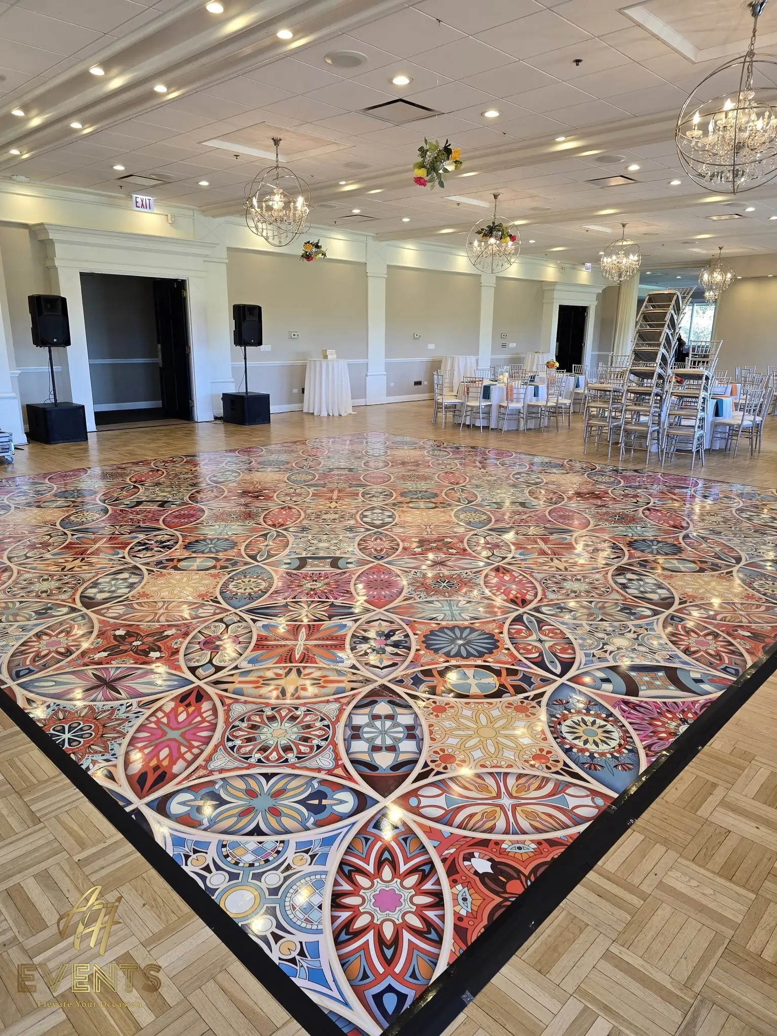 Kaleidoscope decorative floor in a bright ballroom with chandeliers and a parquet border