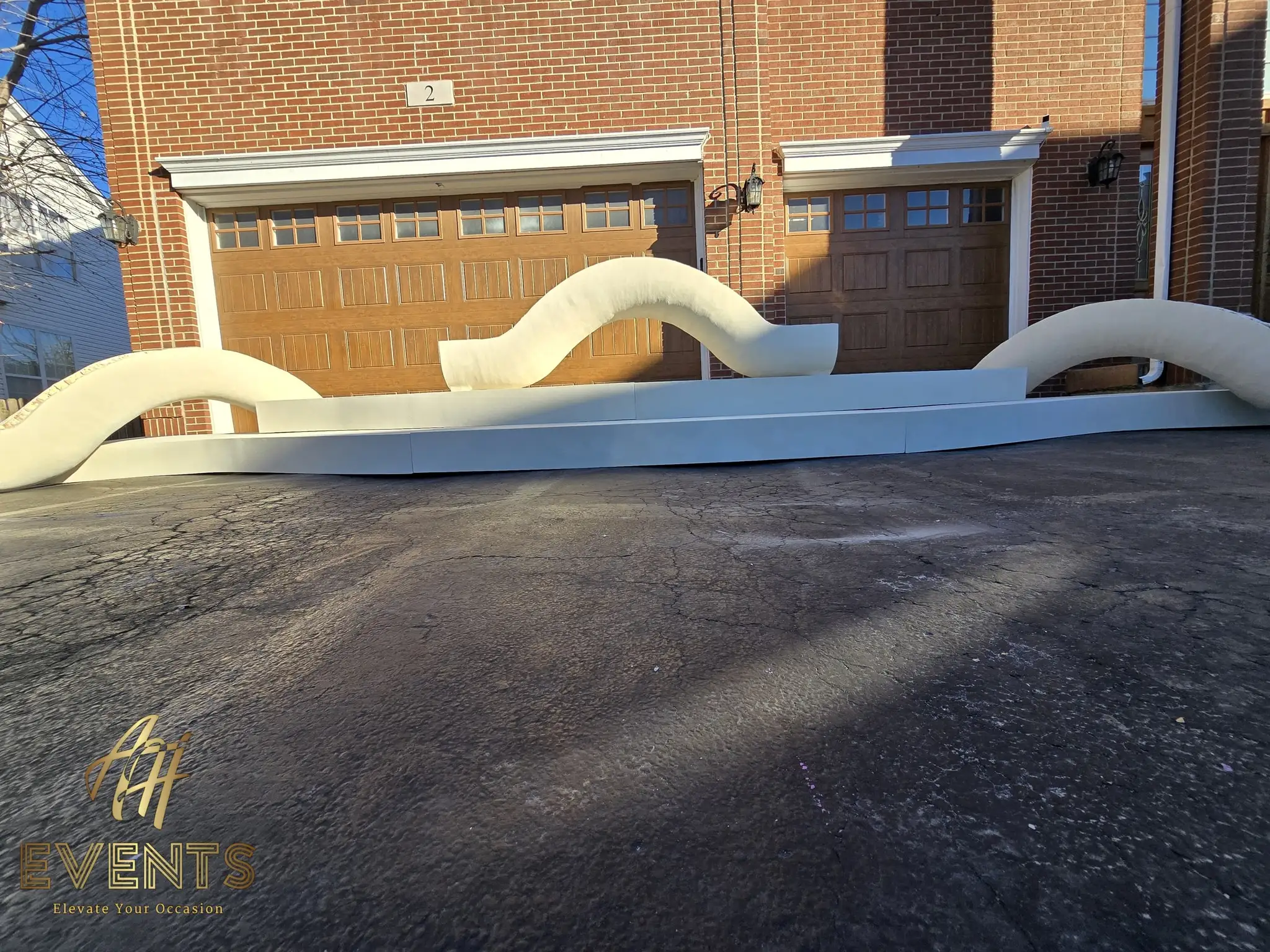 The full serpentine contoured stage backdrop with multiple humps on a white riser in the driveway