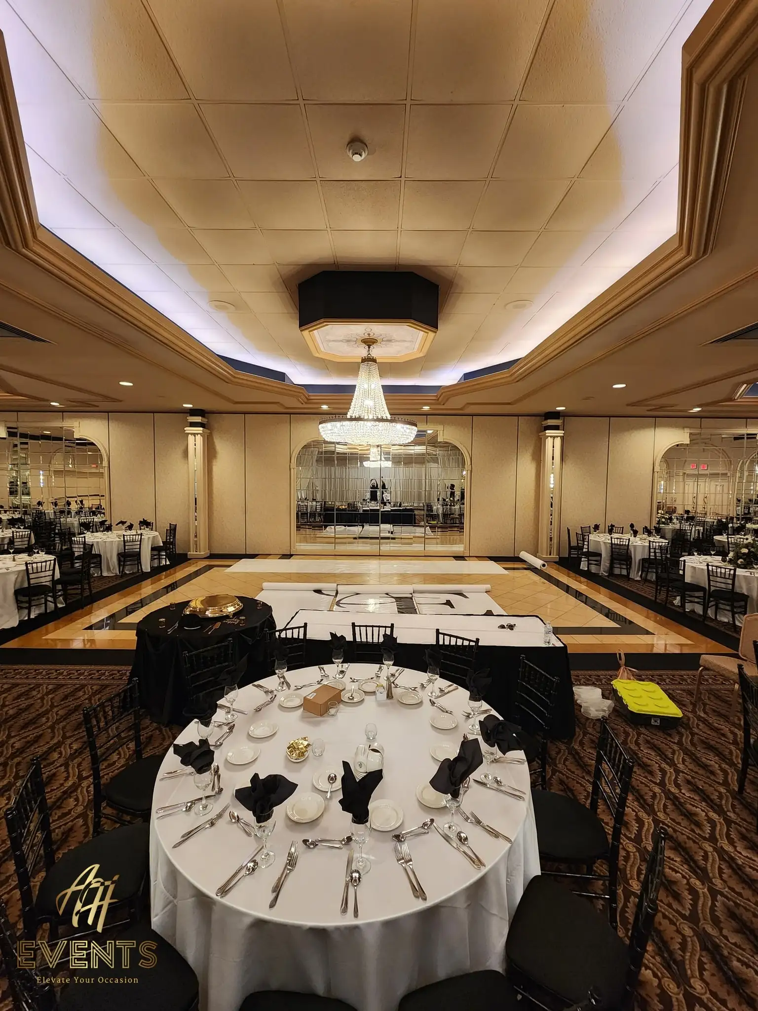 Elevated view of the ballroom with the white 'A&E' monogram dance floor centered among round tables