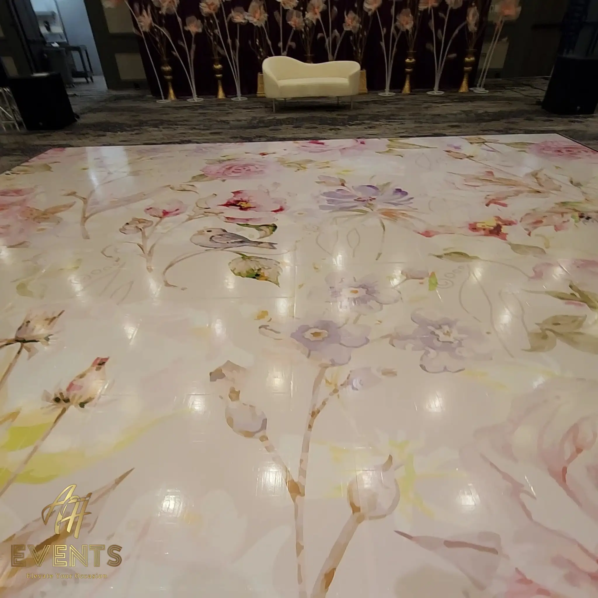 Close view of the pastel floral floor showing watercolor roses and a small bird, the floral stage behind