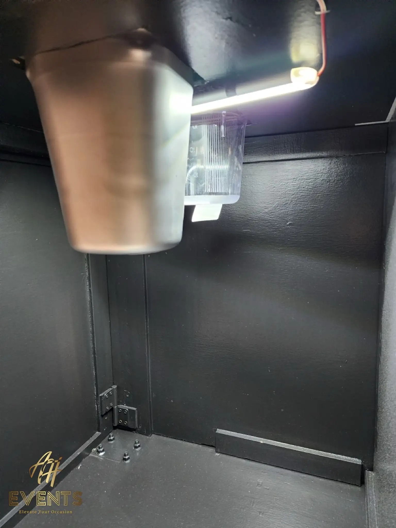 Interior of the Bobawala cart showing an under-counter stainless cup funnel and a warm LED light bar with wiring