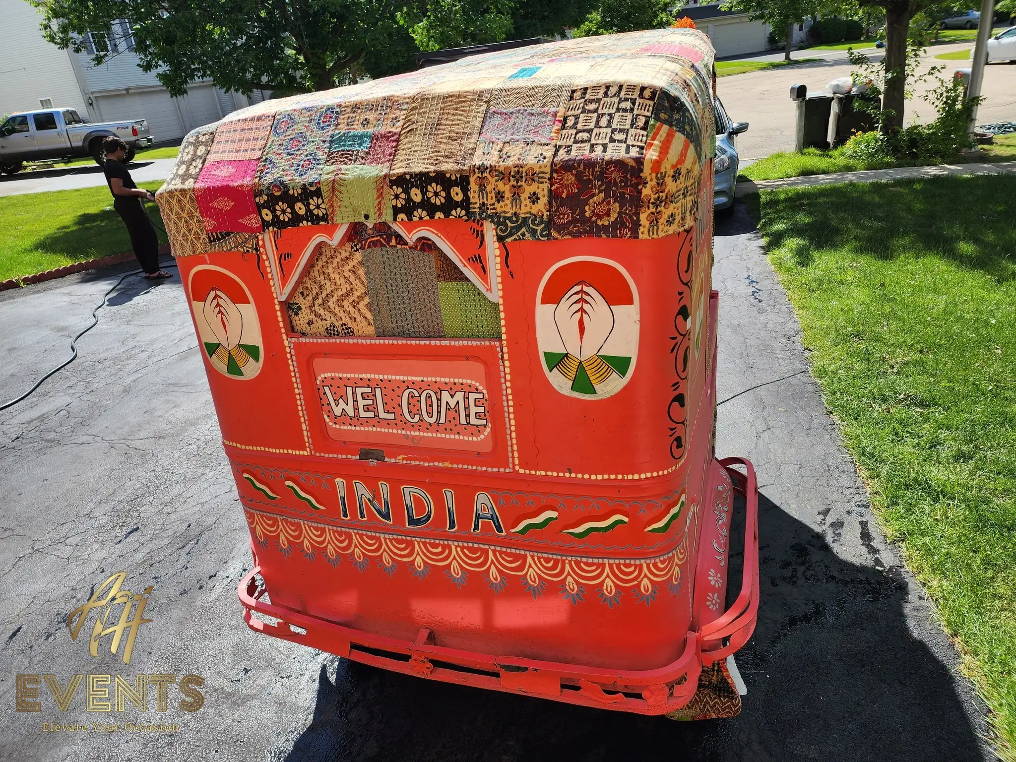 Rear of the auto rickshaw hand-painted 'Welcome India' beneath a patchwork-covered roof