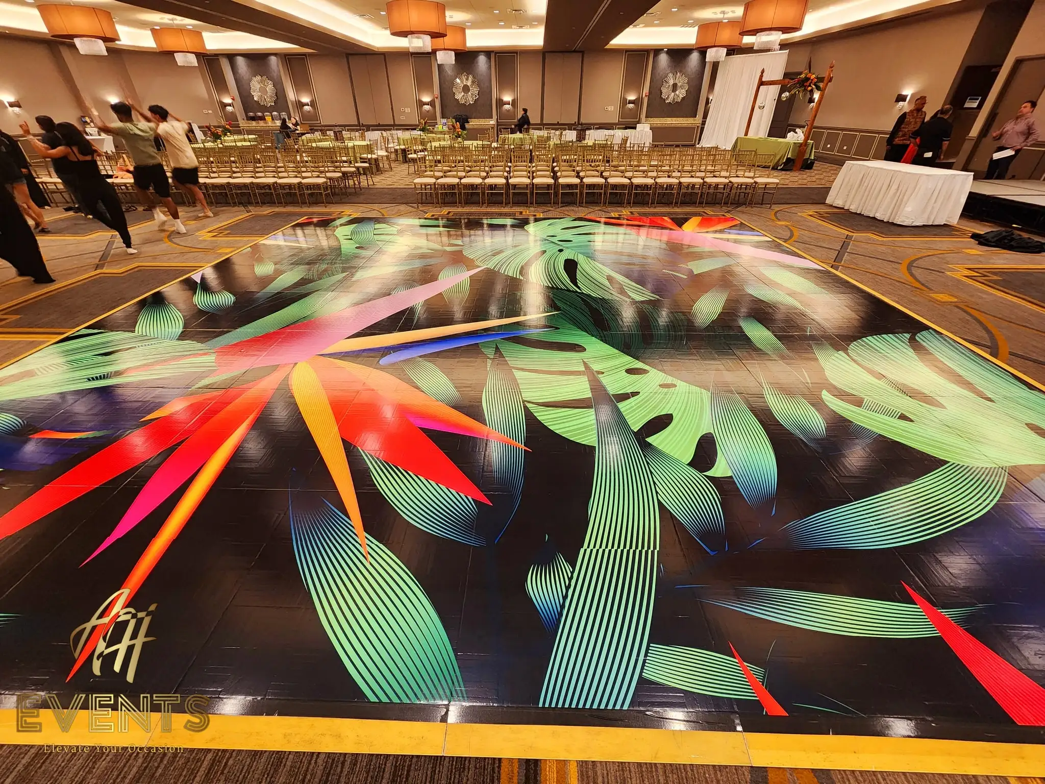 Tropical leaf-art dance floor with bird-of-paradise motifs, chairs lining the ballroom