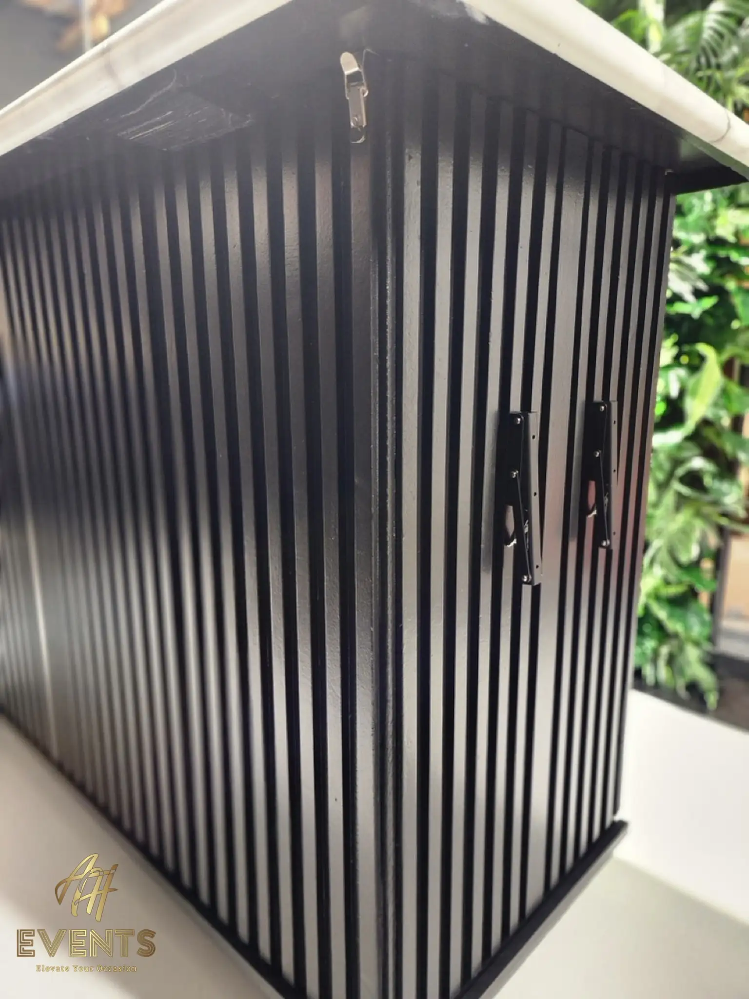 Side of the Bobawala cart showing the black vertical-slat panel with a silver latch and folding brackets