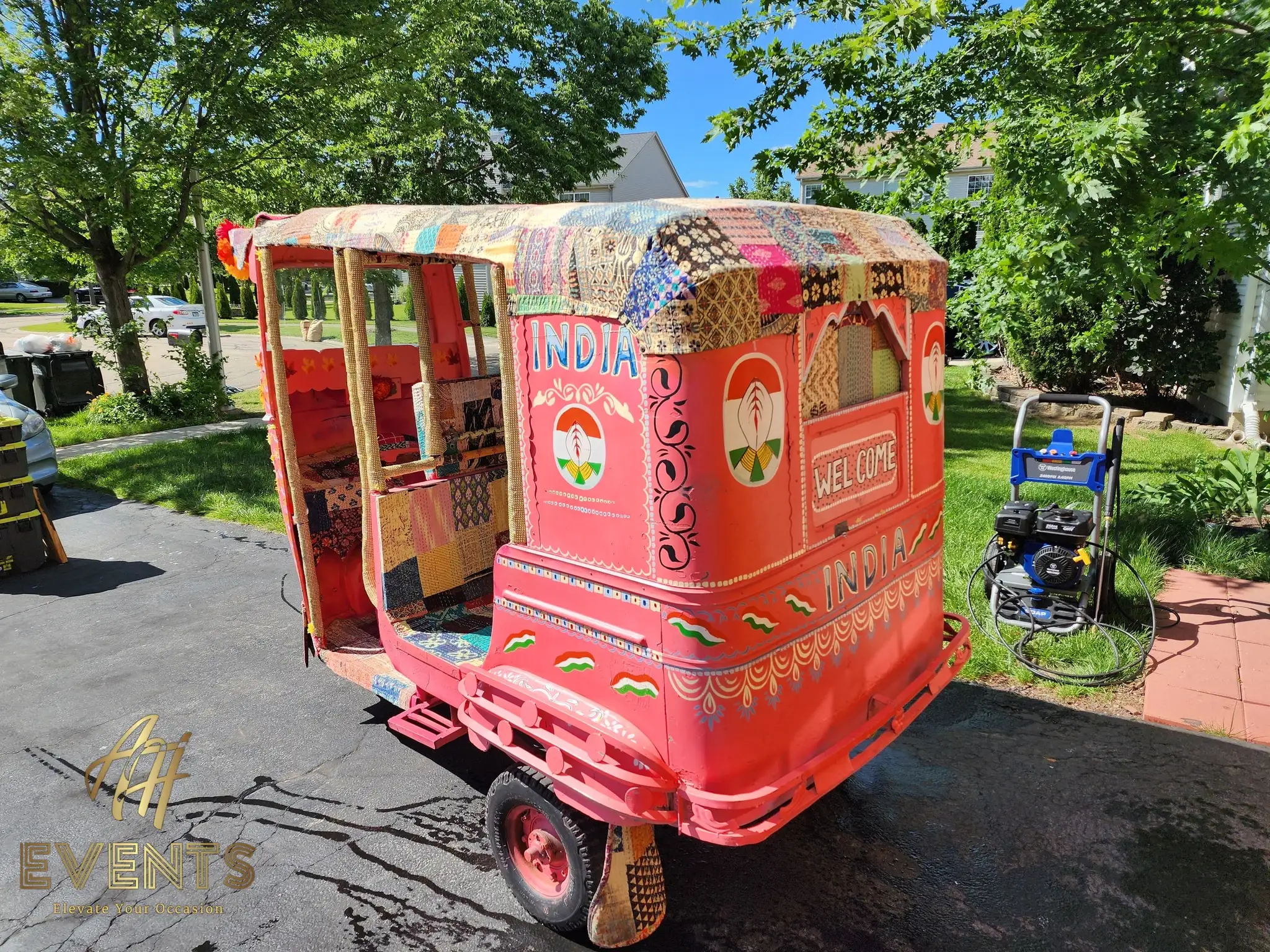 Rear three-quarter view of the auto rickshaw with 'India' and 'Welcome' painted panels
