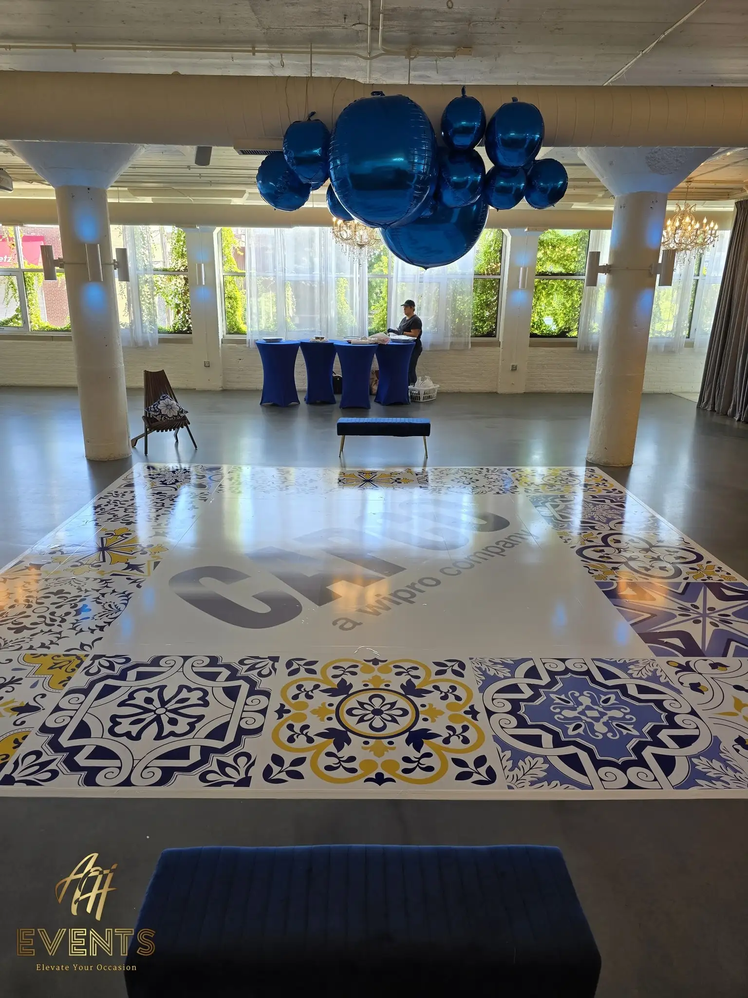 CAPCO tiled dance floor in the loft with blue balloons and a guest at the registration table