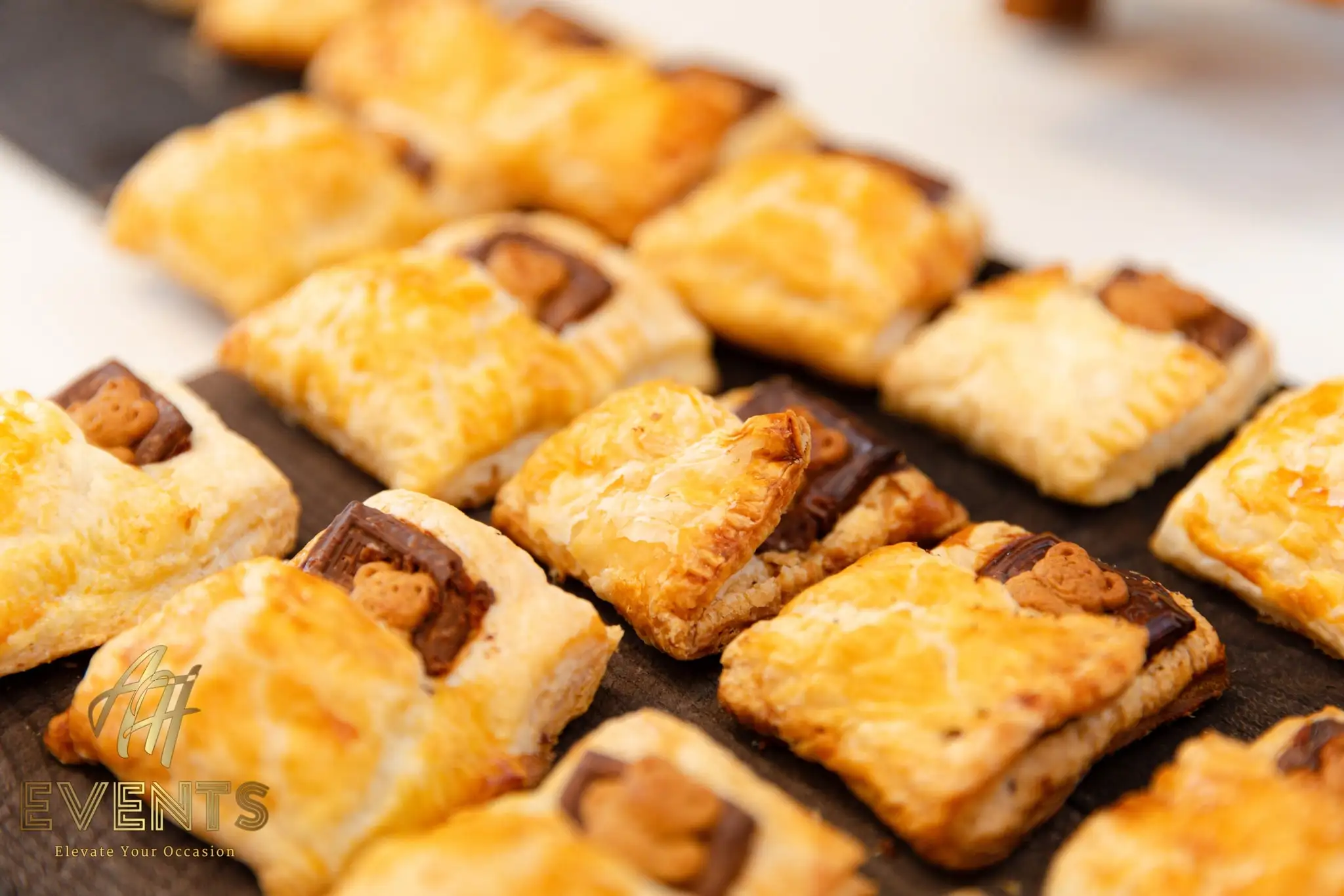 Rows of golden puff-pastry bites topped with chocolate and teddy-bear crackers