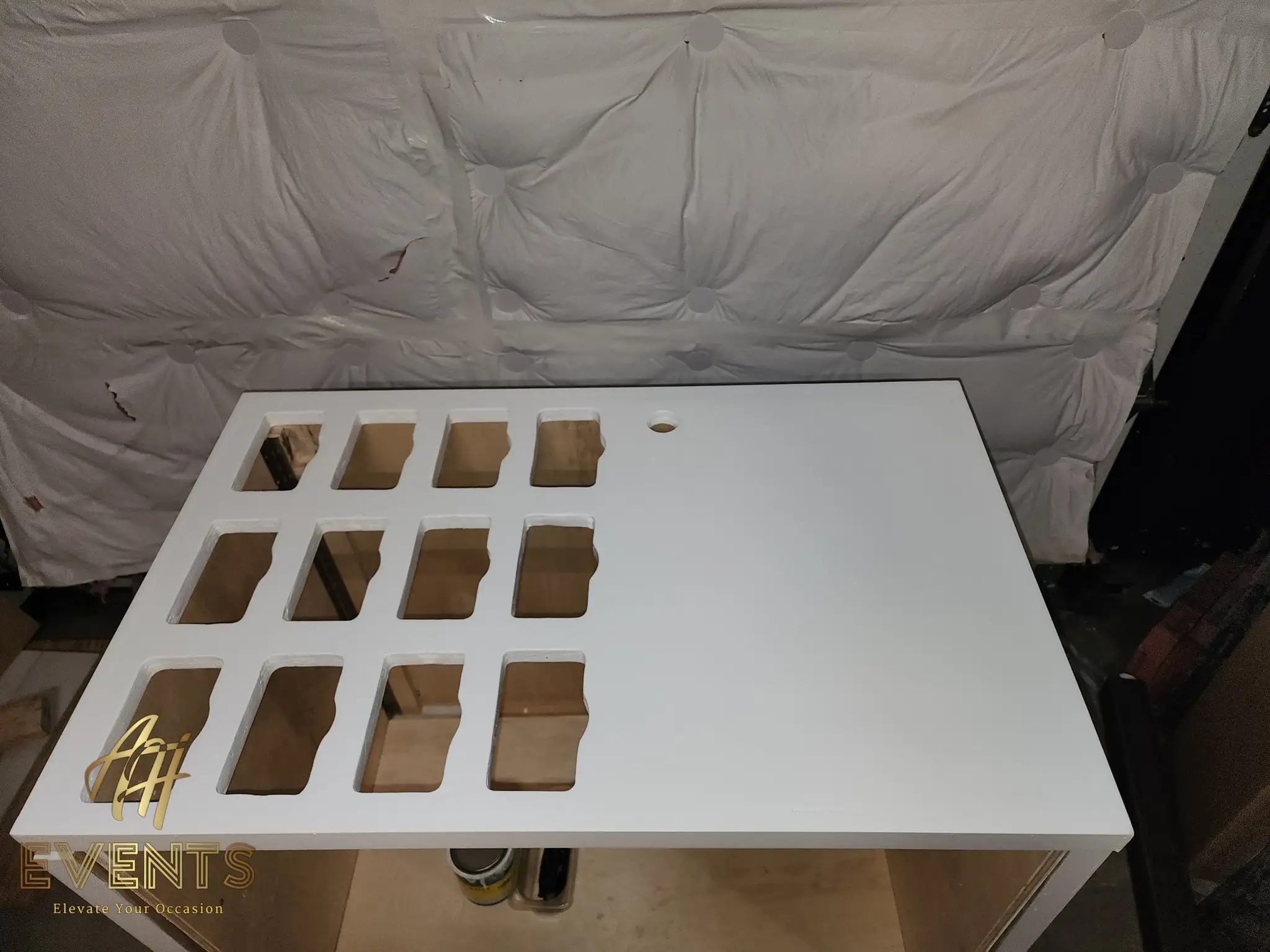 Finished glossy white cart top with a 3-by-4 grid of scalloped rectangular cup wells, against a spray-booth drape