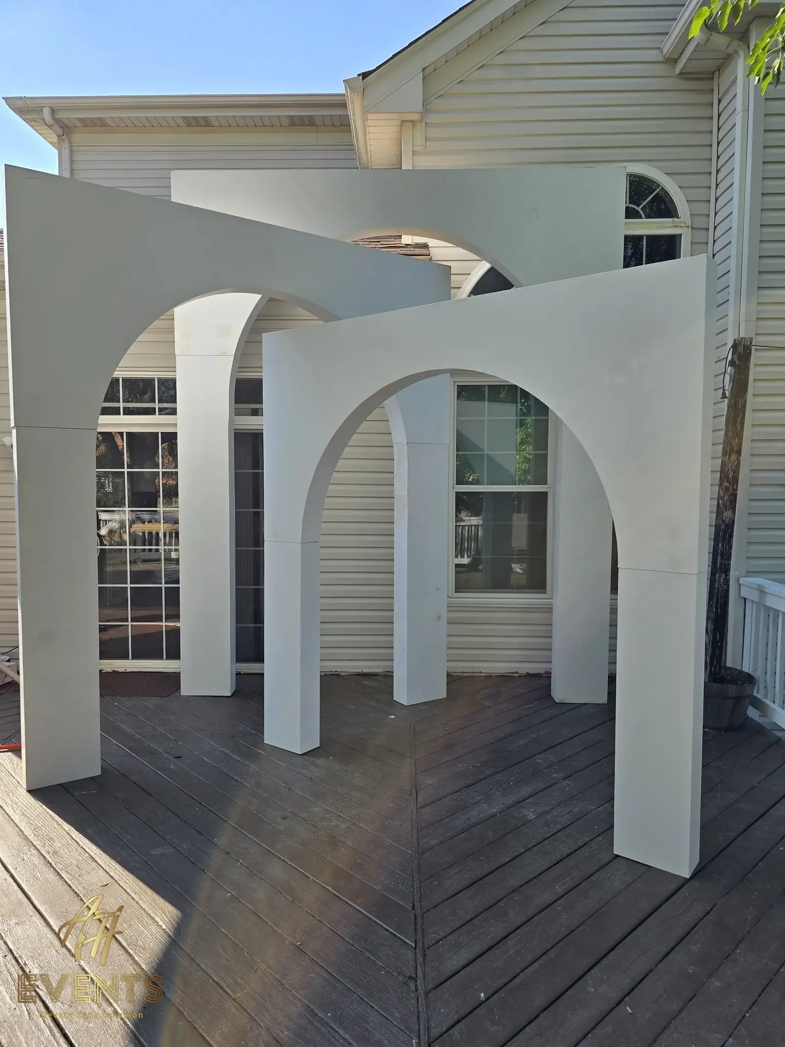 Nested white arches viewed at an angle on a backyard deck