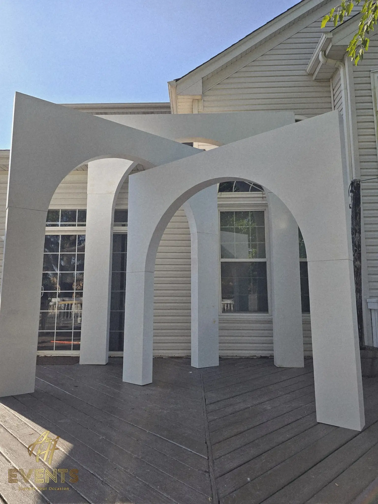 Three graduated white arches on a deck in the afternoon sun