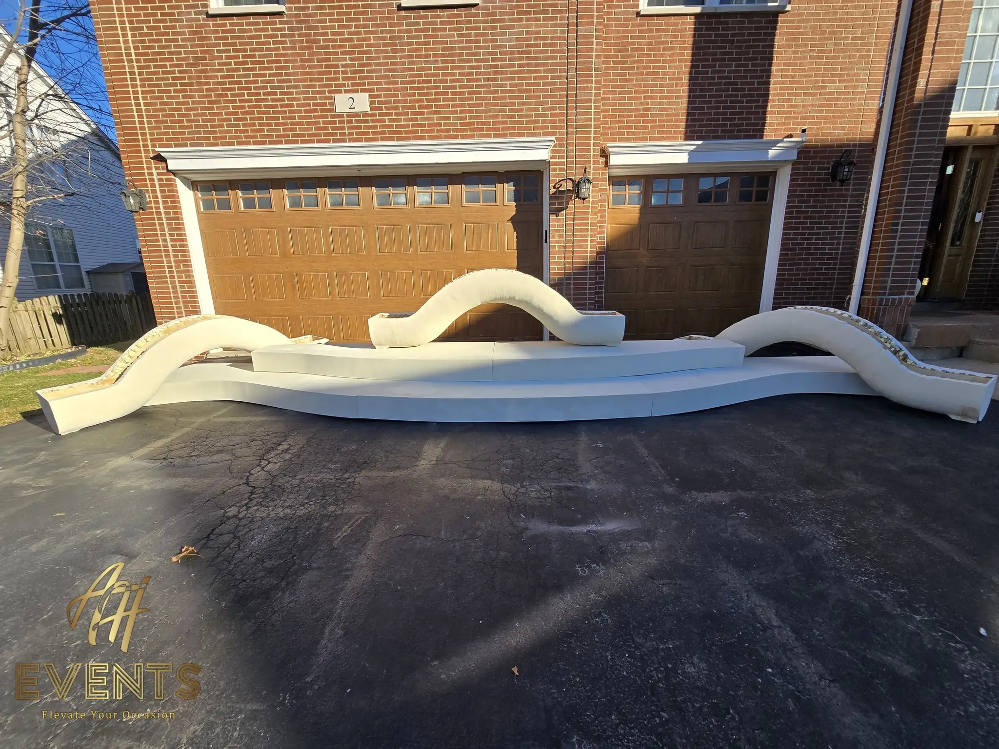 The serpentine multi-hump stage backdrop on a white riser in the driveway