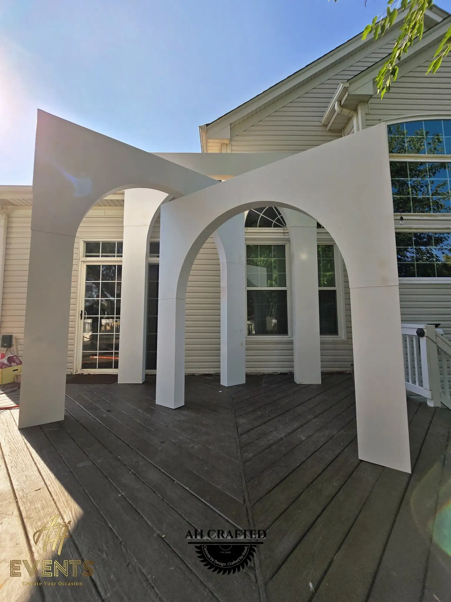 The nested white volumetric arch suite on a deck, marked with the AH Crafted logo