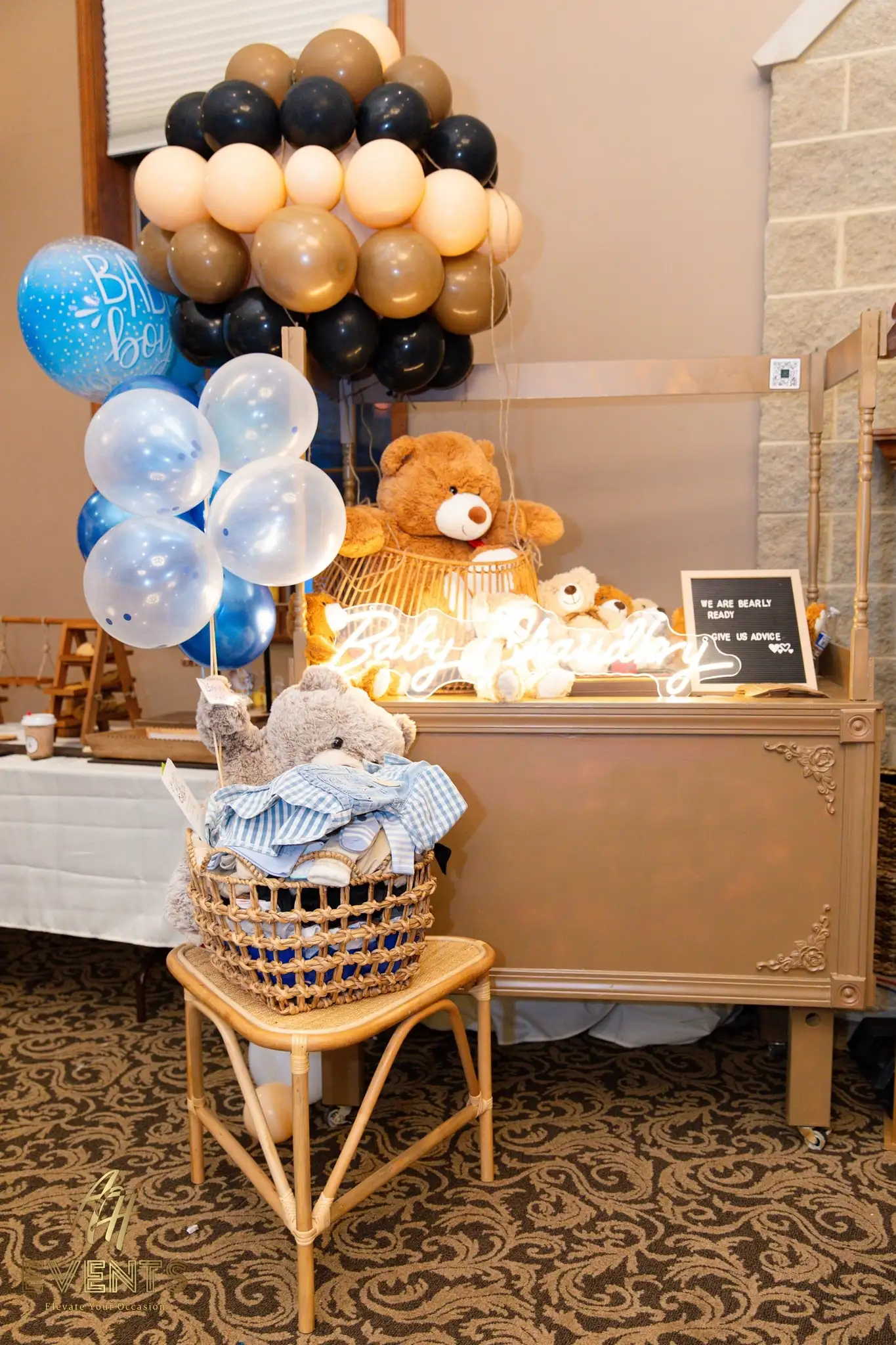 Gold cart with a brown teddy, blue and tan balloons, 'Baby Boy' balloons and a neon 'Baby Shower' sign