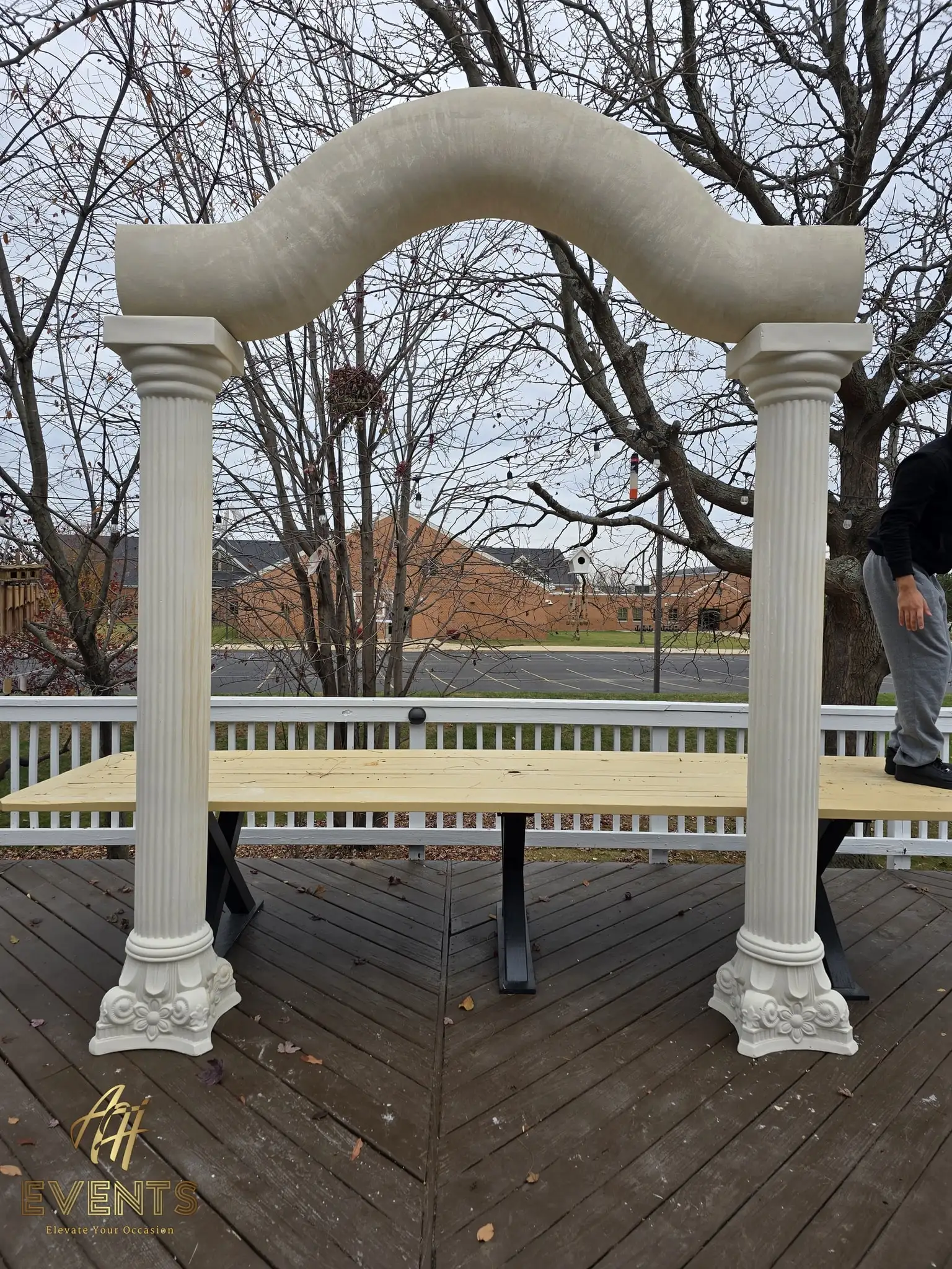 Assembled classical columns and serpentine arch over the raw plywood stage deck