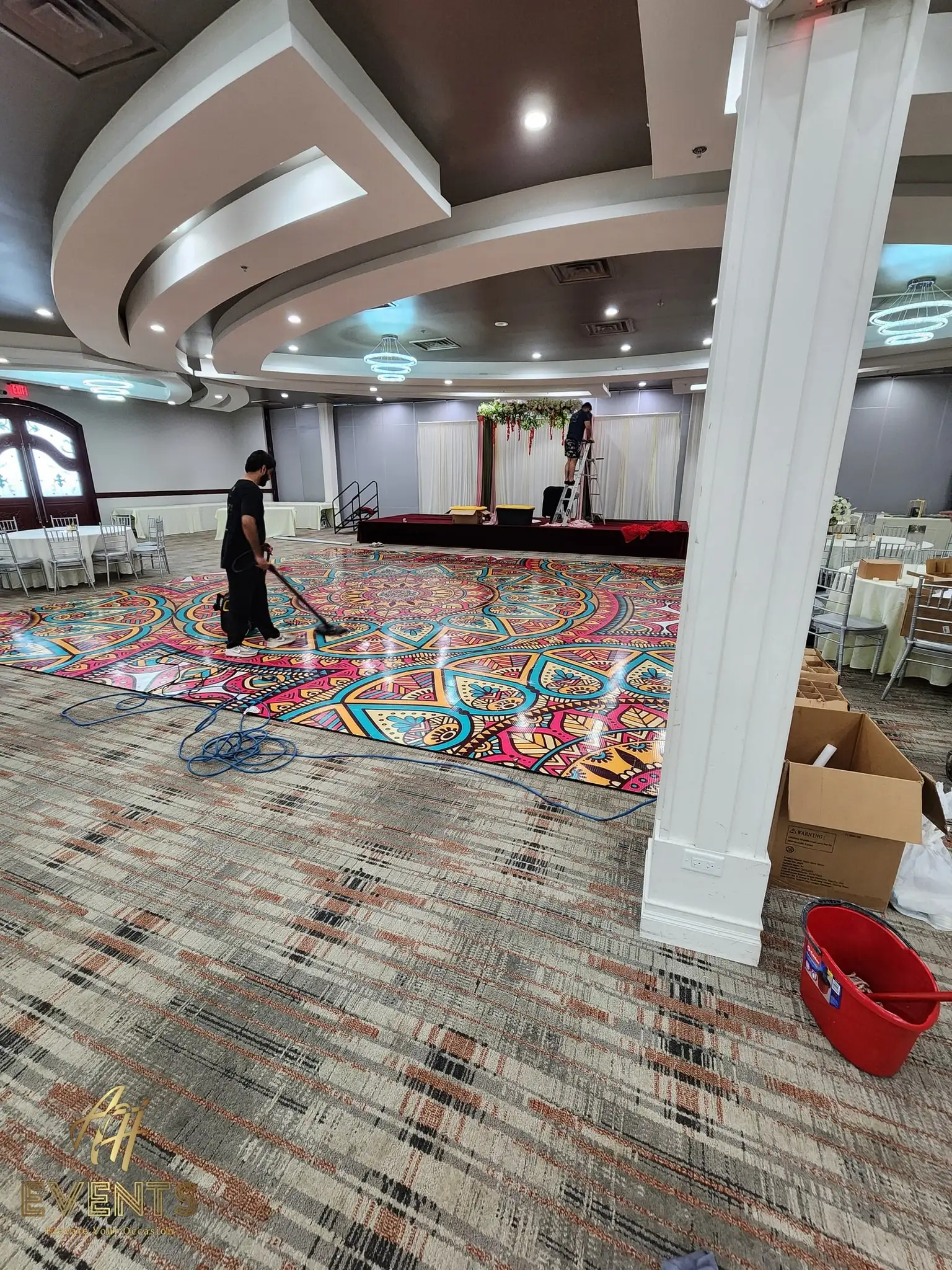 Mandala floor being mopped and cleaned during installation in a banquet hall