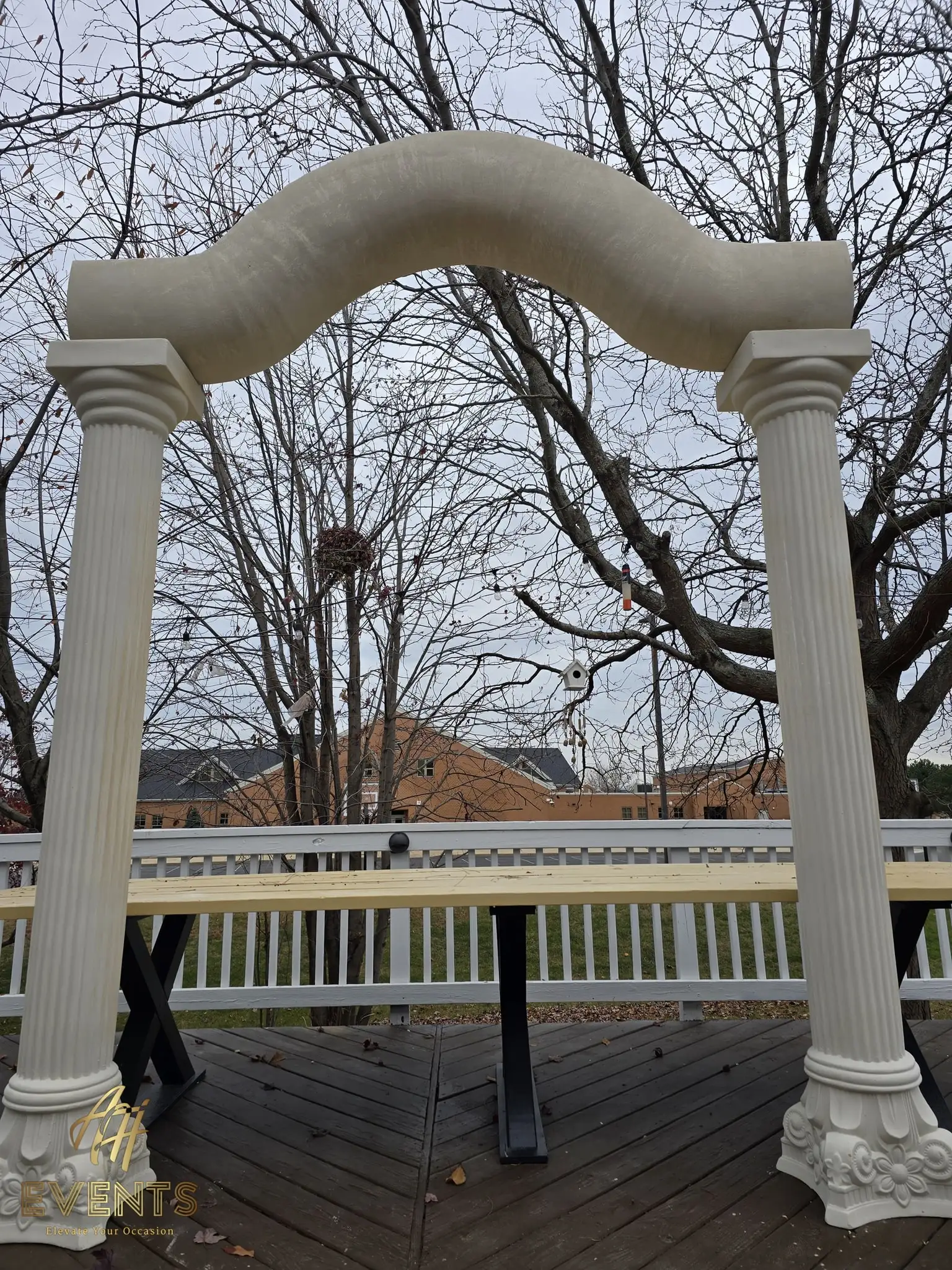 The fluted columns and serpentine arch on the deck, head-on view with the deck railing behind