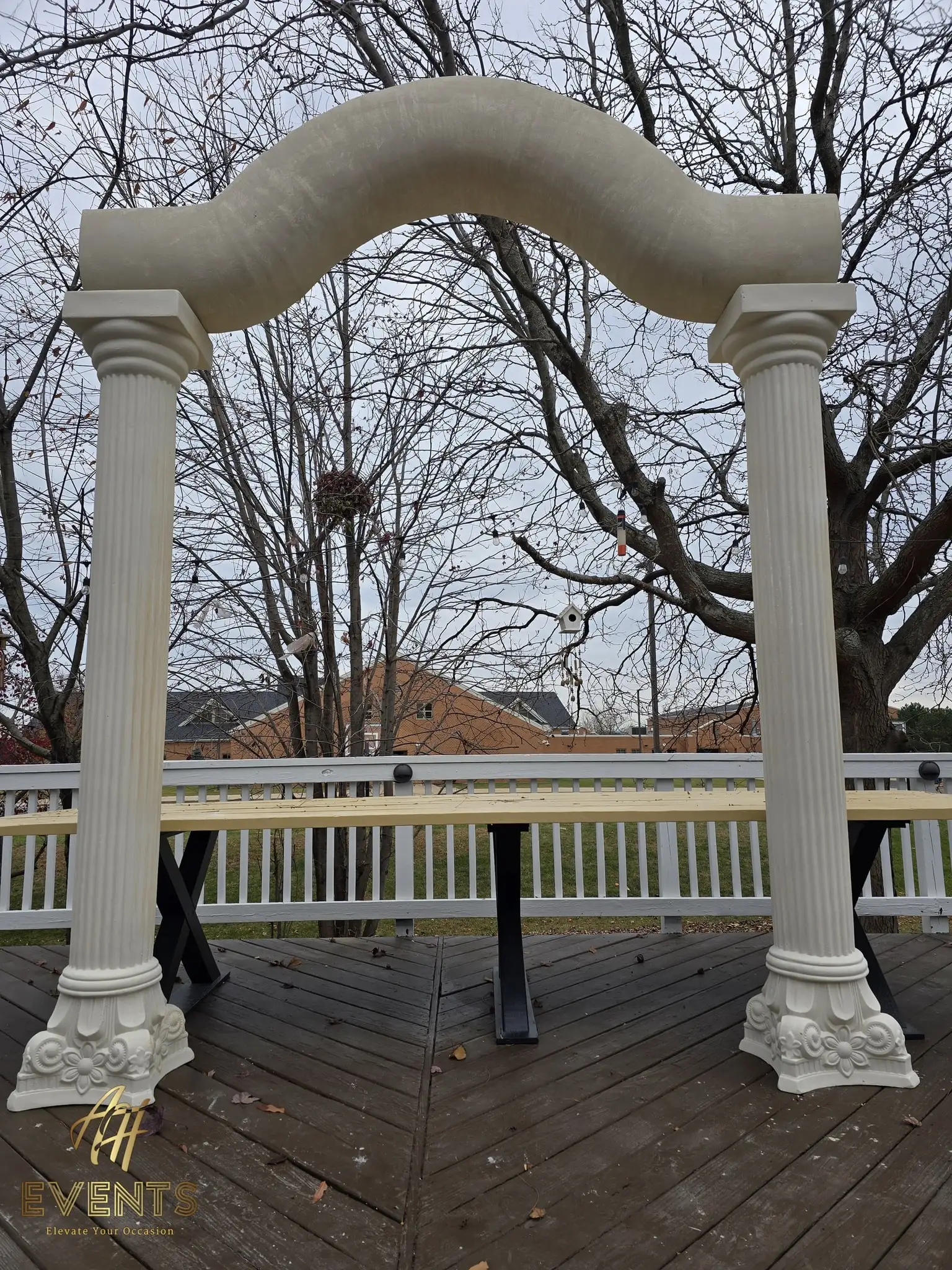 Classical columns and serpentine arch on the deck, viewed straight on against the trees