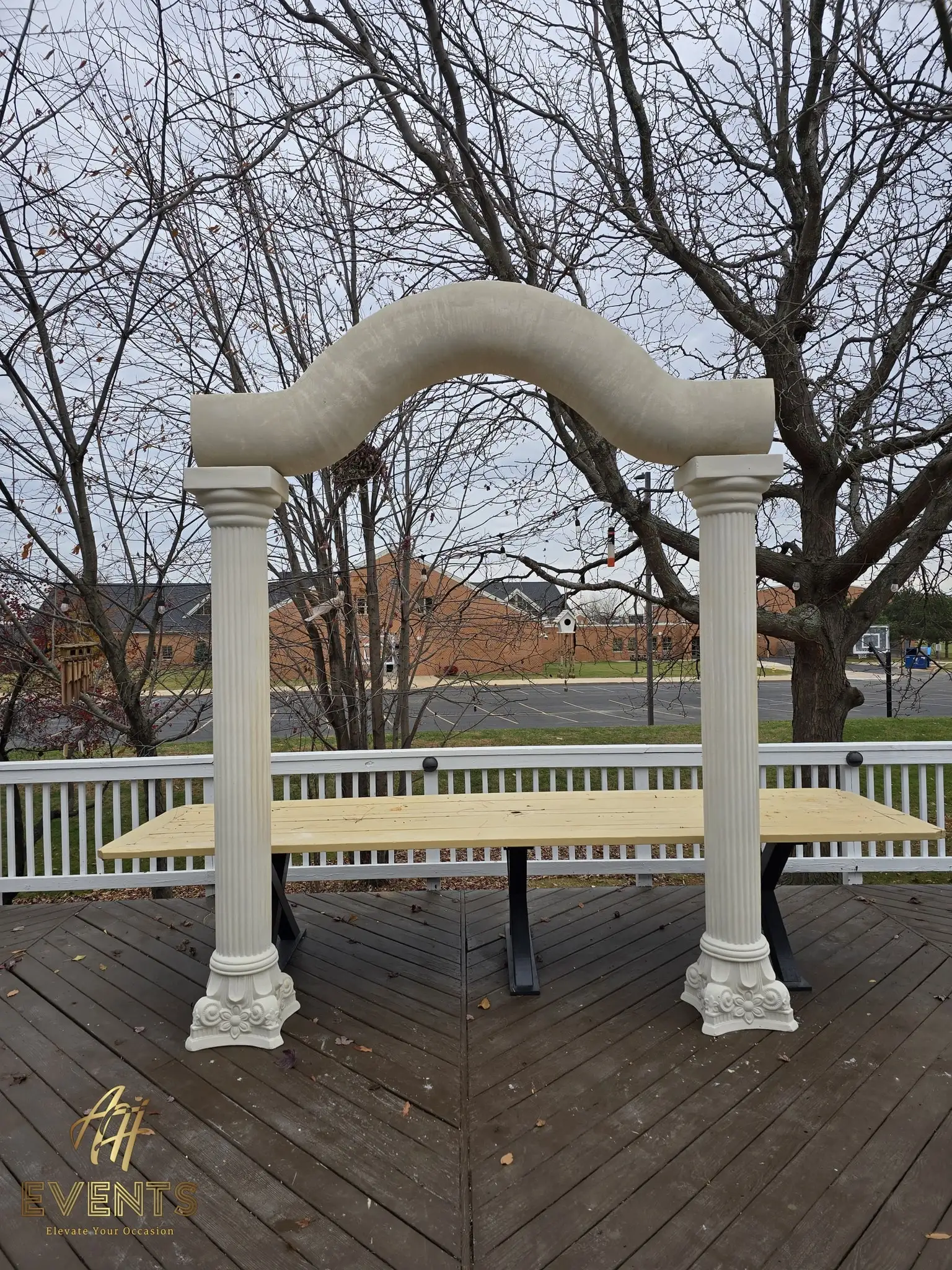 Classical columns and serpentine arch above the bare plywood stage top