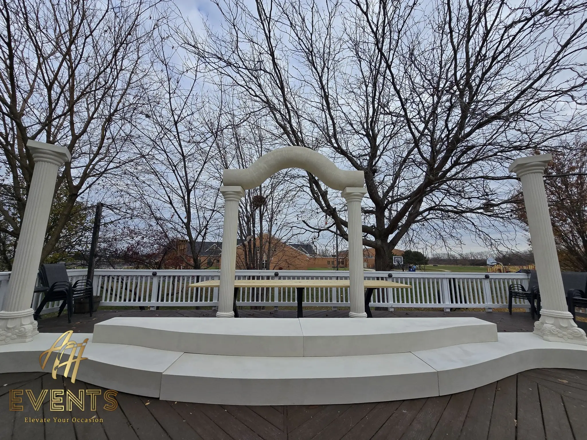 The completed classical-pillar stage on the deck, a curved riser leading up to the fluted columns and serpentine arch